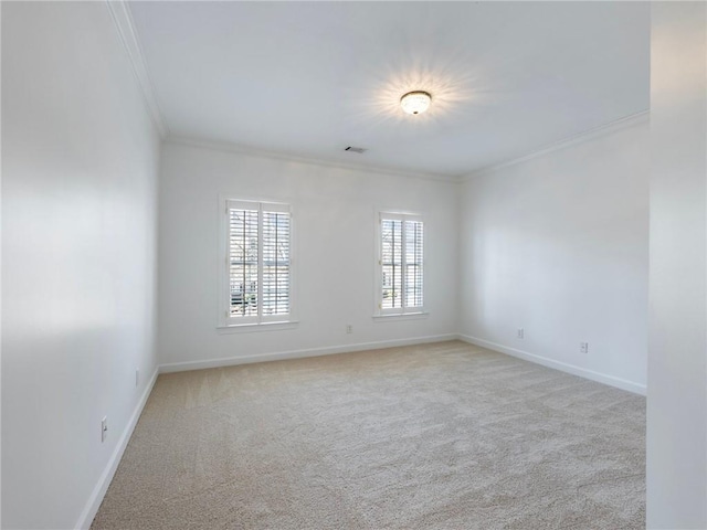 empty room featuring crown molding and light colored carpet