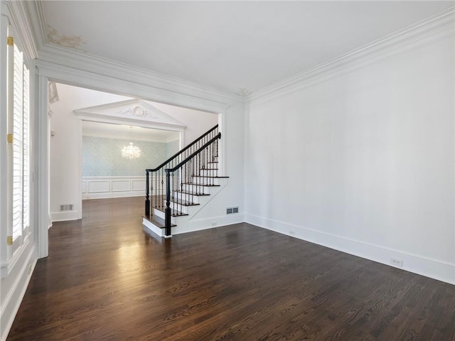 interior space featuring dark hardwood / wood-style flooring, lofted ceiling, ornamental molding, and an inviting chandelier