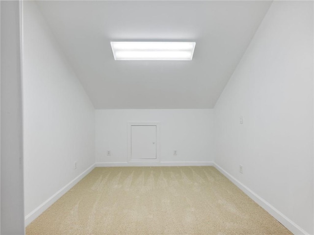 bonus room featuring vaulted ceiling and light colored carpet