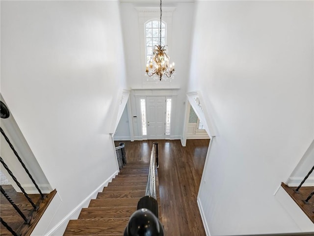 foyer with an inviting chandelier and dark hardwood / wood-style flooring