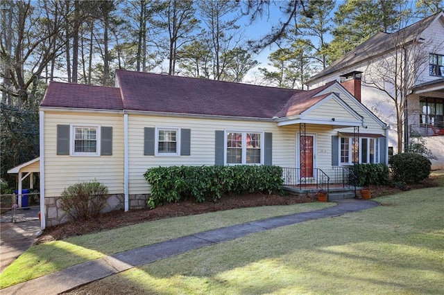 view of front of home with a chimney, a front lawn, and a shingled roof