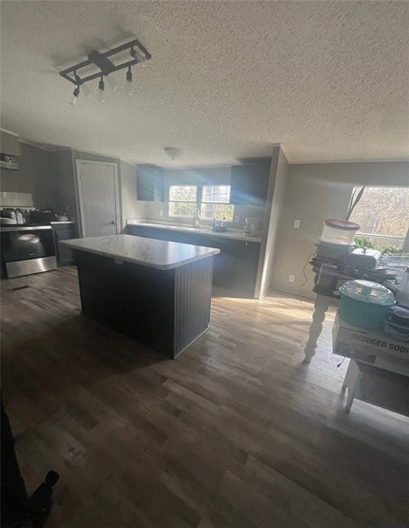 kitchen with dark hardwood / wood-style flooring, a textured ceiling, electric range, a center island, and rail lighting