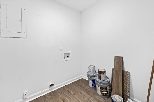 clothes washing area featuring hookup for a washing machine, electric panel, baseboards, and wood finished floors