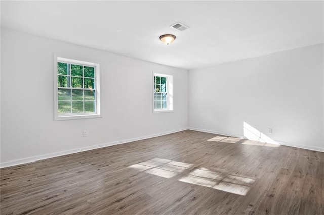 empty room featuring wood finished floors and baseboards