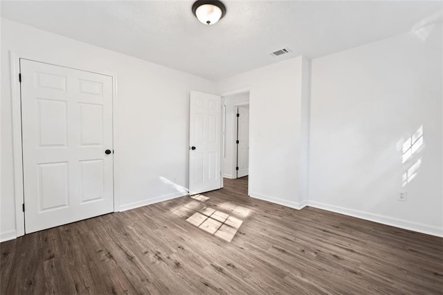unfurnished bedroom with baseboards and wood finished floors