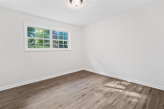 empty room featuring wood finished floors and baseboards
