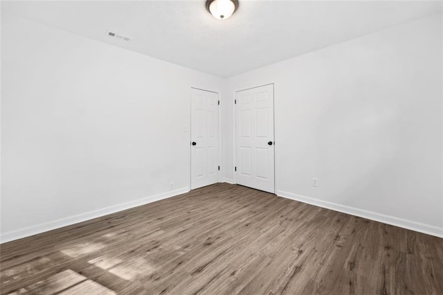 unfurnished room featuring baseboards and wood finished floors