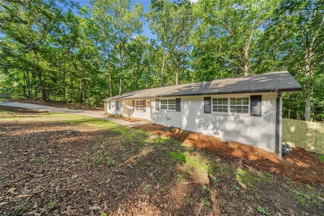 view of front of home featuring brick siding and fence