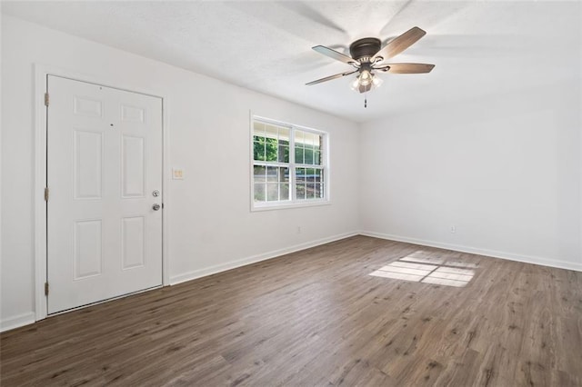 foyer featuring wood finished floors, baseboards, and ceiling fan
