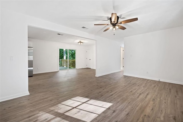 unfurnished room featuring a ceiling fan, wood finished floors, and baseboards