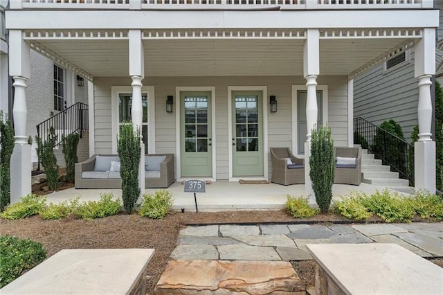 view of patio featuring stairs and a porch