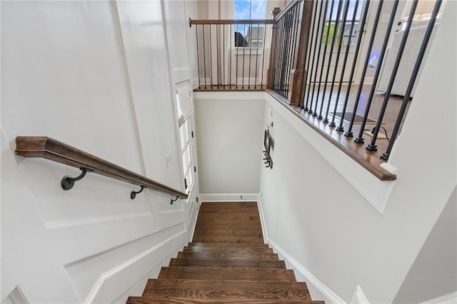 staircase featuring baseboards and wood finished floors