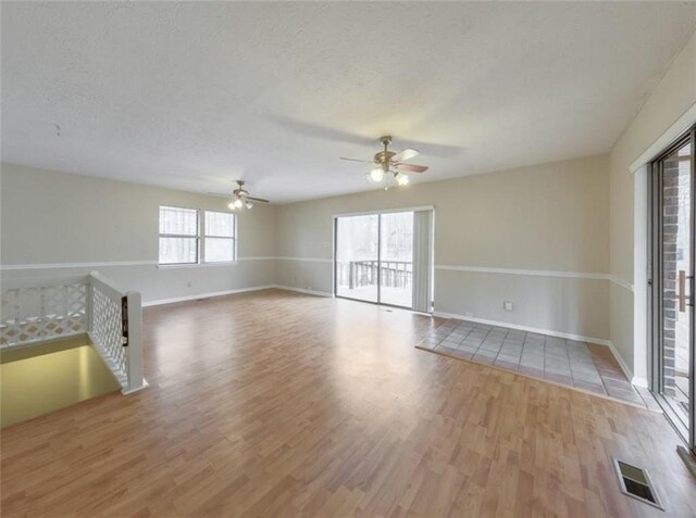 unfurnished room featuring ceiling fan, a textured ceiling, and light hardwood / wood-style flooring