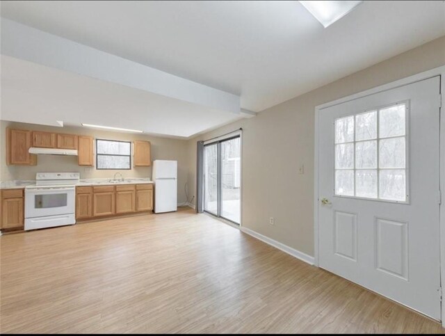 kitchen featuring light wood-type flooring, white appliances, and sink