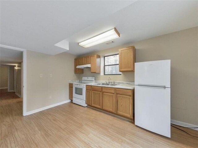 kitchen with white appliances, sink, and light hardwood / wood-style flooring