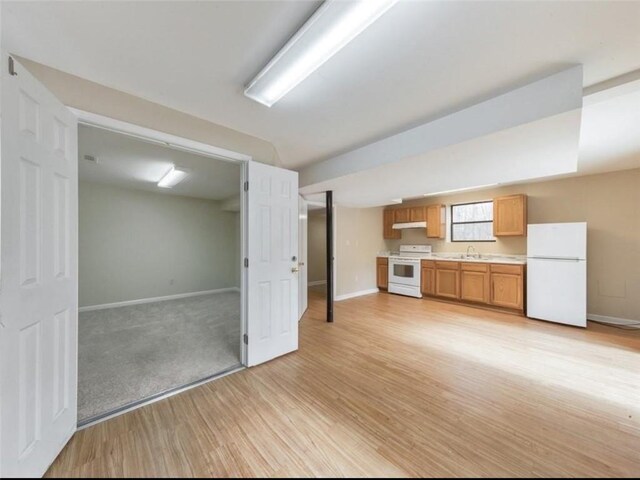 interior space featuring light hardwood / wood-style floors, white refrigerator, and sink