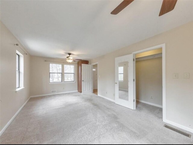 spare room with ceiling fan and light carpet