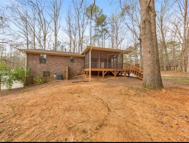 rear view of property with cooling unit and a sunroom