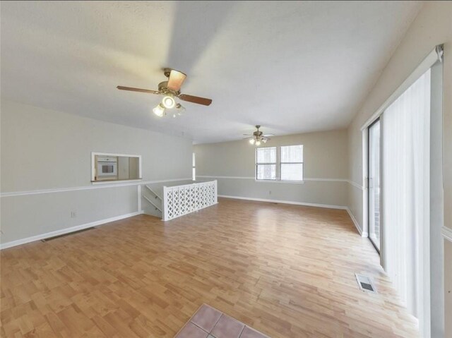 unfurnished living room featuring light wood-type flooring and ceiling fan