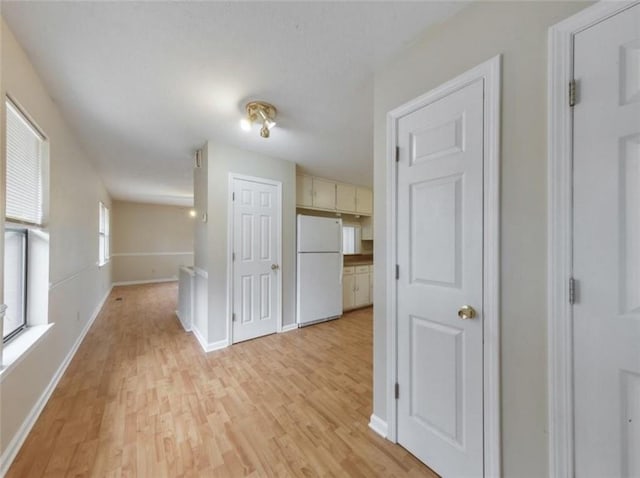 hall featuring light wood-type flooring and plenty of natural light