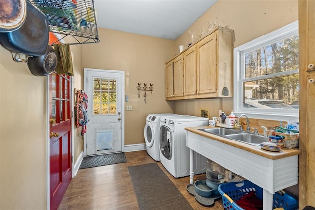 laundry room with cabinet space, baseboards, washer and clothes dryer, dark wood-style floors, and a sink