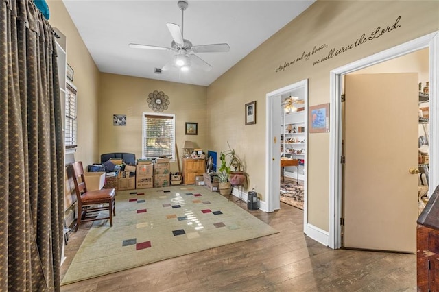 sitting room with a ceiling fan, wood-type flooring, visible vents, and baseboards