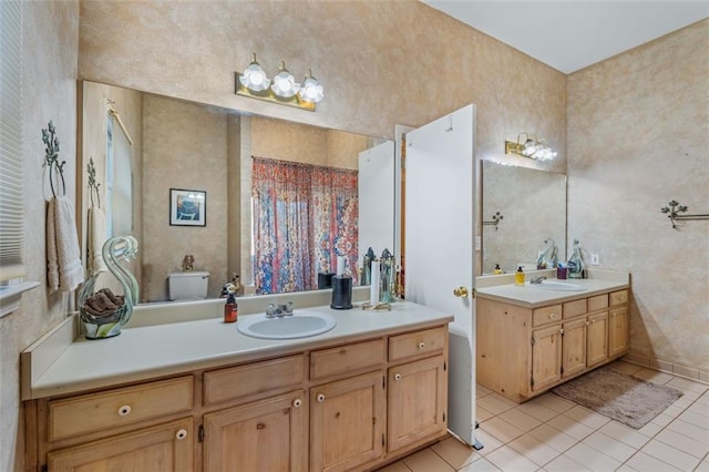 bathroom featuring two vanities, a sink, and tile patterned floors