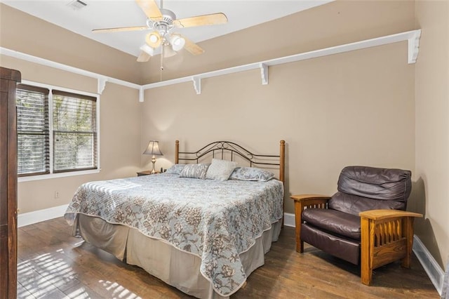 bedroom with ceiling fan, wood finished floors, and baseboards