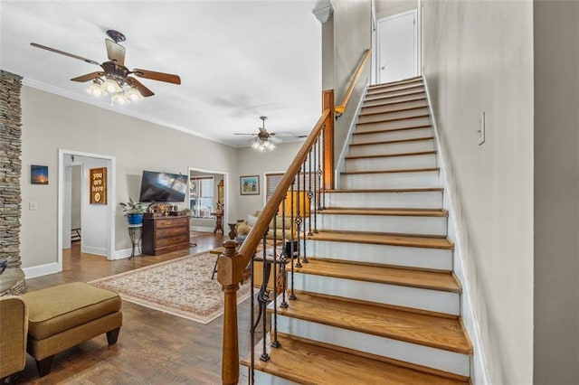 stairway featuring ornamental molding, a ceiling fan, baseboards, and wood finished floors