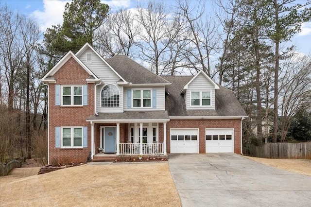 view of front facade featuring a porch, an attached garage, brick siding, fence, and driveway