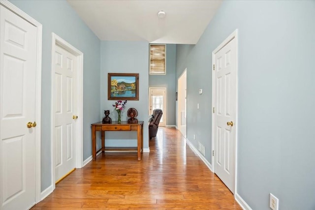 hallway with light wood-style flooring and baseboards