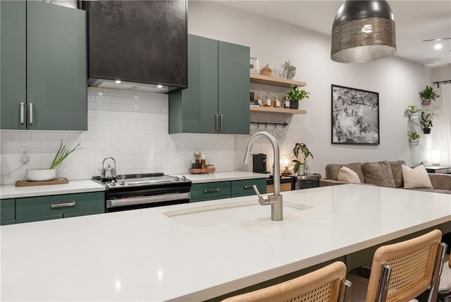 kitchen with a breakfast bar area, decorative backsplash, stainless steel range oven, and green cabinetry