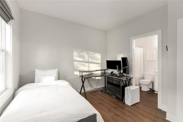 bedroom with dark hardwood / wood-style floors, ensuite bath, and multiple windows