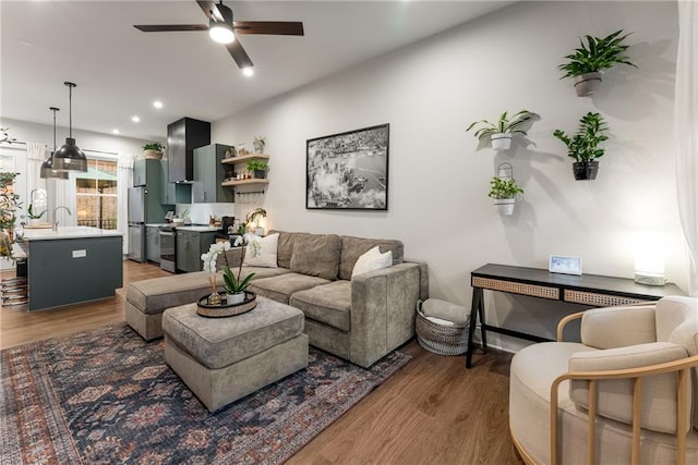 living room featuring ceiling fan, dark hardwood / wood-style flooring, and sink