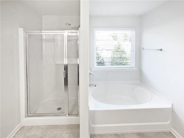 bathroom with separate shower and tub and tile patterned flooring