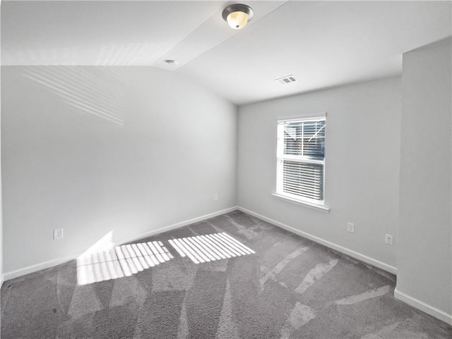 carpeted spare room with lofted ceiling