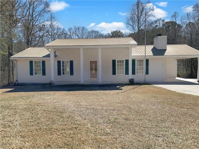 view of front of property with a chimney, a front lawn, and metal roof