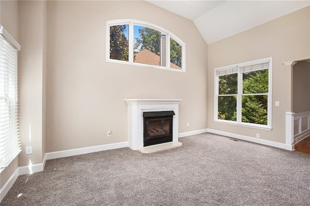 unfurnished living room featuring carpet floors, a healthy amount of sunlight, and lofted ceiling