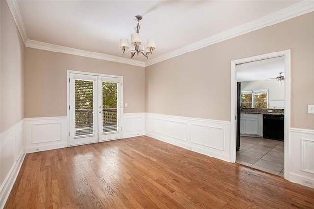 unfurnished room with french doors, crown molding, hardwood / wood-style floors, and ceiling fan with notable chandelier