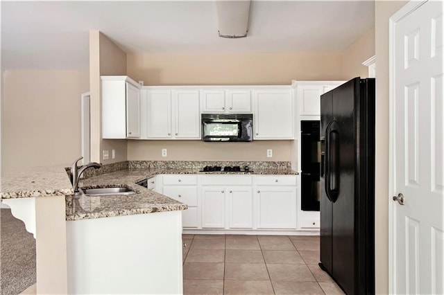 kitchen featuring sink, white cabinets, kitchen peninsula, light tile patterned flooring, and black appliances