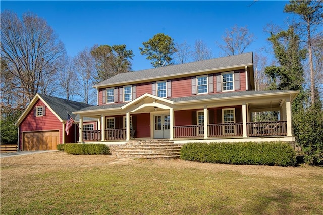 colonial house featuring a garage, a porch, an outdoor structure, and a front yard