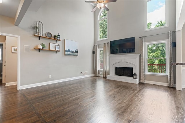 1758 Rosehedge Way NW, Kennesaw, GA 30152 - unfurnished living room featuring a high ceiling, ceiling fan, dark wood-style flooring, baseboards, and a fireplace