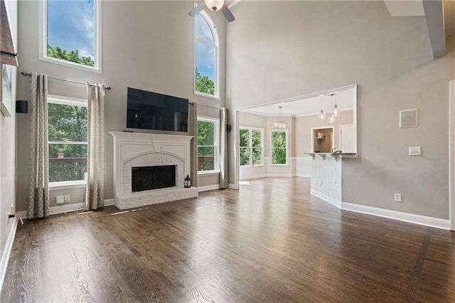 1758 Rosehedge Way NW, Kennesaw, GA 30152 - unfurnished living room featuring a towering ceiling, ceiling fan, a brick fireplace, baseboards, and wood finished floors