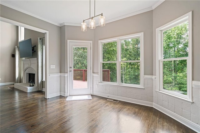 1758 Rosehedge Way NW, Kennesaw, GA 30152 - unfurnished dining area featuring dark wood-type flooring, ornamental molding, a wainscoted wall, a fireplace with raised hearth, and a chandelier