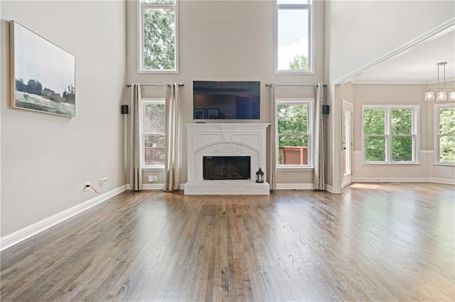 1758 Rosehedge Way NW, Kennesaw, GA 30152 - unfurnished living room featuring wood finished floors, a high ceiling, plenty of natural light, a brick fireplace, and baseboards