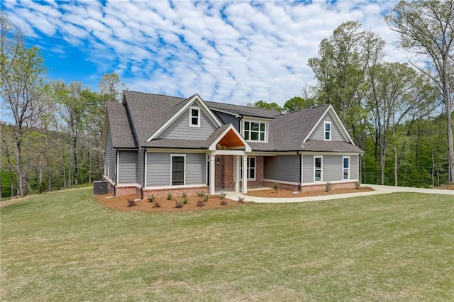 craftsman-style home with central air condition unit and a front yard