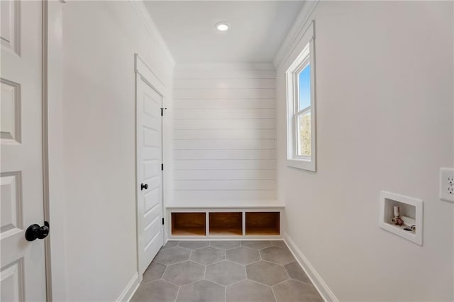 mudroom featuring ornamental molding and light tile patterned floors