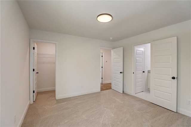 unfurnished bedroom featuring a closet and a spacious closet