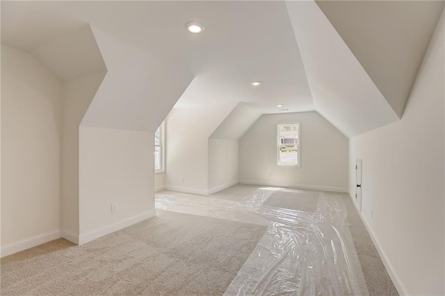 bonus room featuring lofted ceiling and light colored carpet