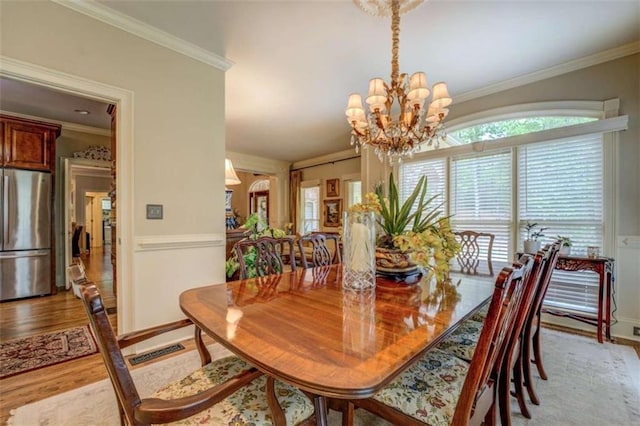 95 Weslyan Way, Oxford, GA 30054 - dining room with crown molding, light wood-style flooring, a chandelier, and baseboards